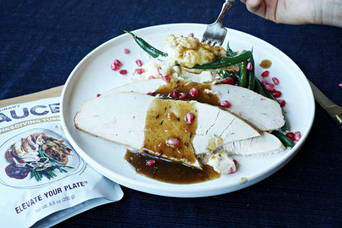 thanksgiving turkey gravy with sliced turkey and green beans with mashed potatoes