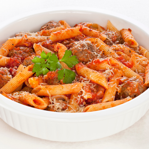Penne pasta with marry me sauce and meat in a white bowl on a white background